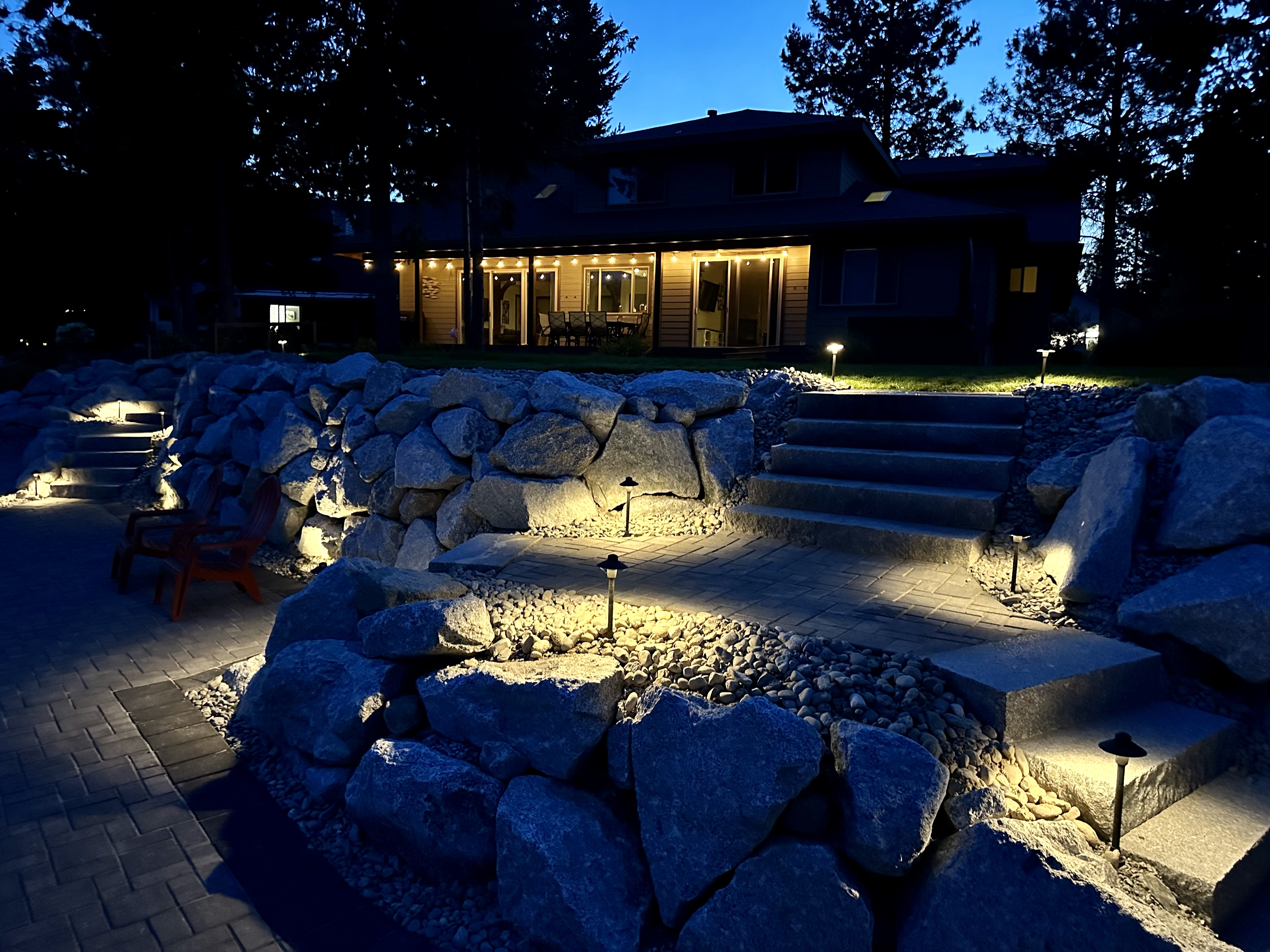 Full property landscape lighting — house, stone terraces, and path lights