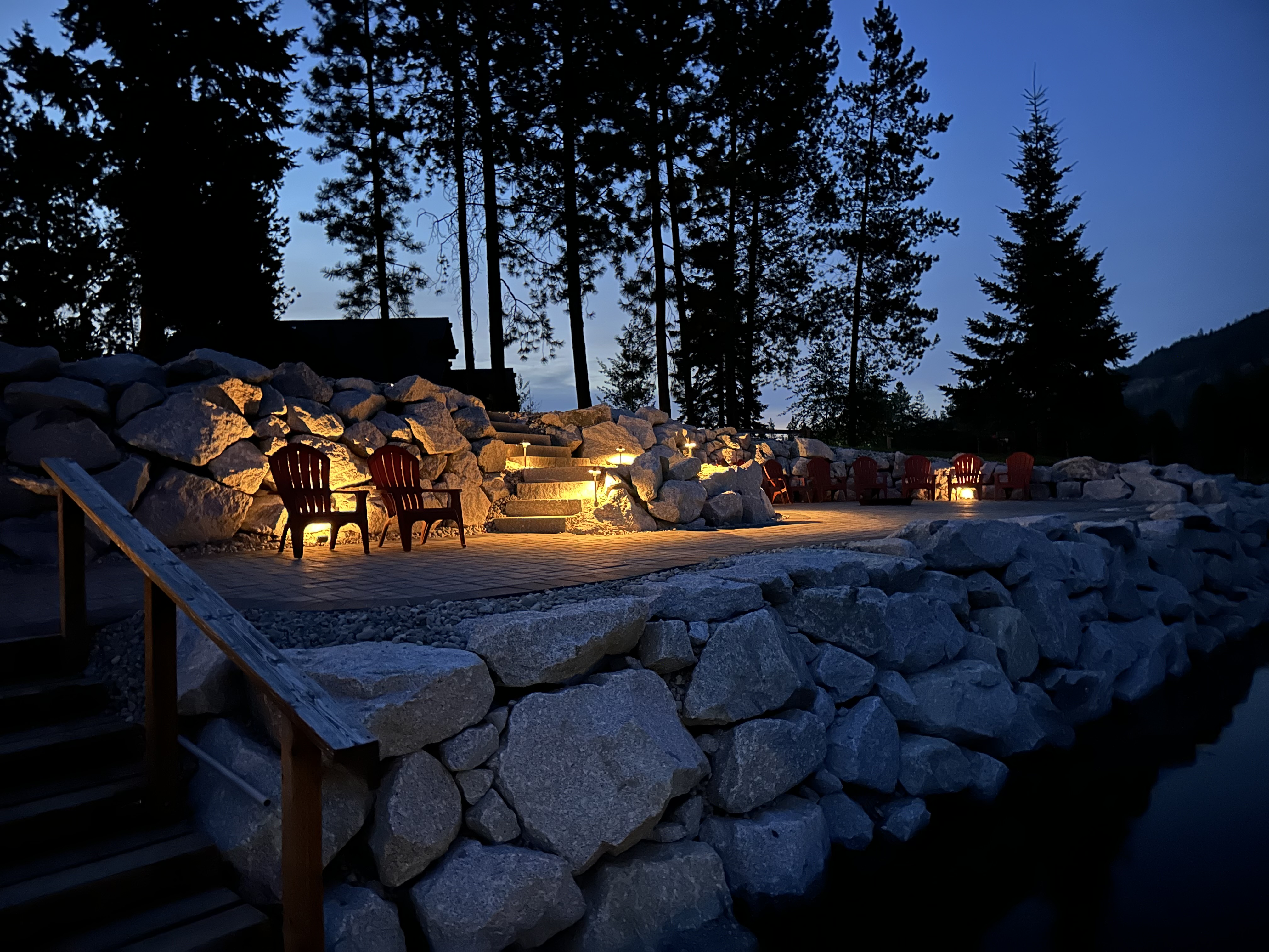 Outdoor fire pit area with warm landscape lighting