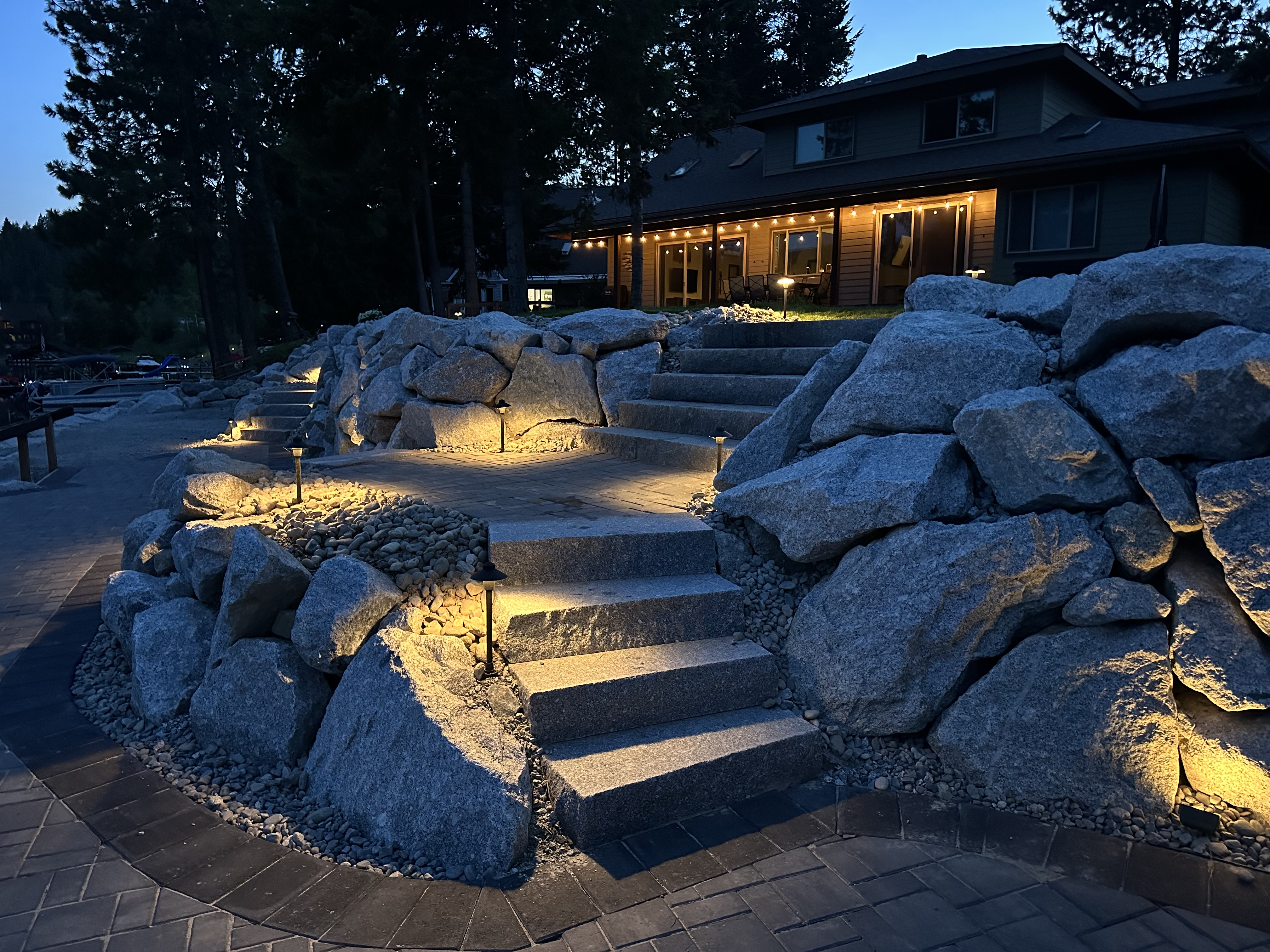 Boulder stairway with warm landscape lighting at dusk