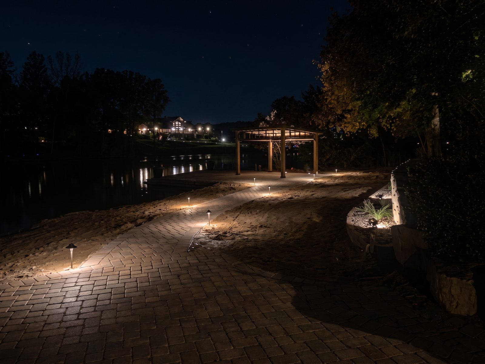 Lakeside pergola with path lights and water reflections — outdoor lighting Sandpoint Idaho