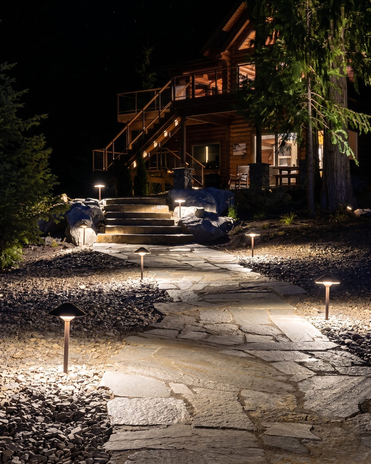 Flagstone path with modern bollard lights leading to a cabin in North Idaho at night